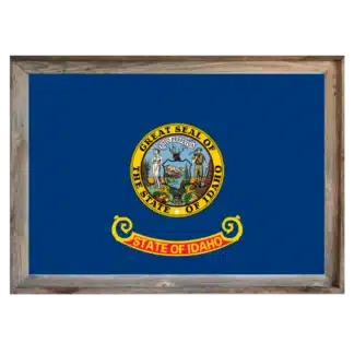 Framed Idaho state flag with deep blue field, gold “Great Seal of Idaho” crest, and rustic reclaimed‑wood frame.