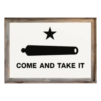 Framed “Come and Take It” flag with black star, cannon, and text on white field, set in rustic light‑wood frame